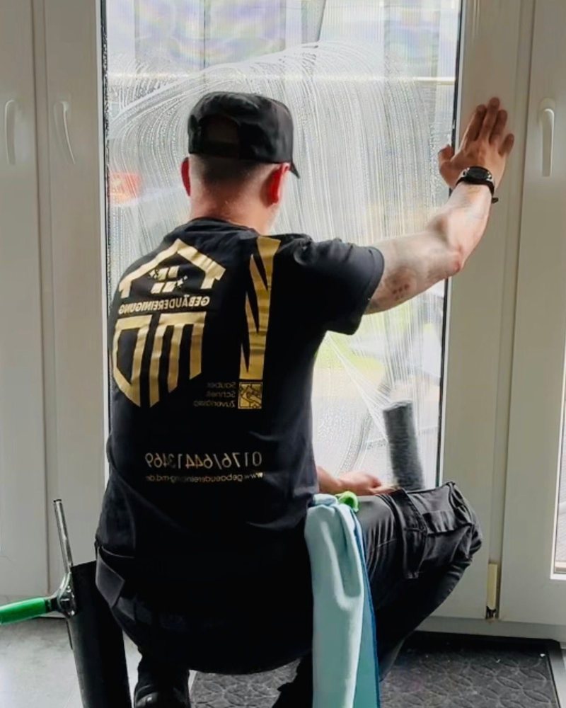 Bedrucktes schwarzes Arbeitsshirt eines Fensterreinigers, von hinten fotografiert